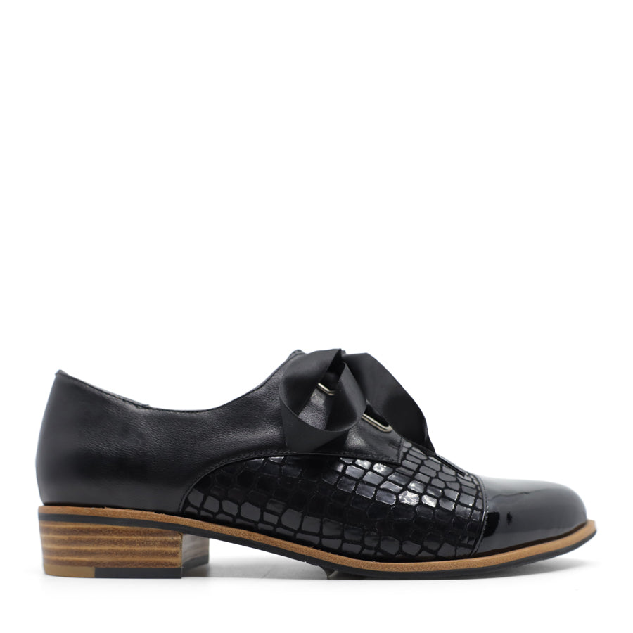 SIDE VIEW OF BLACK LEATHER PATENT FLAT SHOE WITH BLACK RIBBON LACES. 